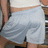 A pixelated image shows a person wearing light blue shorts and brown shoes, with partial views of arms and legs visible.
