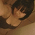 Animated sequence of a person with short dark hair in a black top, showing hand movements near the face against a light brown background.