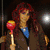 A collage of six pixelated images featuring a woman with long red hair in various poses and outfits, including holding a lollipop and wearing a black dress.
