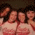 Four pixelated figures in light-colored tops with dark hair, positioned closely together against a brown background.
