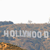 Static image of a large sign with white letters spelling 'HOLLYWOOD' on a brownish background with blue and orange tones.