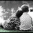 Black-and-white pixelated image of two figures embracing, with text reading 'so in love <3' on the right side.