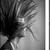 Black-and-white pixelated image of a figure with flowing hair and a light-colored garment against a gradient background.