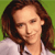 Pixelated close-up of a person with long brown hair wearing a light-colored shirt against a green background.