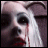 Pixelated close-up of a pale face with dark eye makeup, red lips, and visible blood dripping from the right eye area.