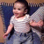 A child in a striped shirt and blue pants stands against a patterned backdrop, with visible differences