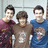 Three pixelated figures stand side-by-side in a static composition, each wearing distinct colored shirts against a light background.