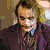 Six show a character with white face paint, red lips, and dark hair in various poses including holding a gun and standing behind bars