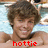 Pixelated image of a person with brown curly hair and light skin, wearing a dark necklace, with red text reading 'hottie' at the bottom.
