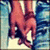 Two hands clasped in a handshake pose, wearing blue jeans and white shoes against a light background.