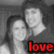 Two pixelated figures in grayscale embrace, with red text 'love' at the bottom right.