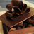 A pixelated image of chocolate pieces with orange text reading "My pup is so much sweeter than chocolate." on a brown background.