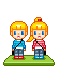 Two pixel-art figures with blonde hair stand on a green base; one wears blue shirt and red pants, the other red striped shirt and gray pants. Animated hearts appear above them.