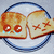 Two slices of toasted bread on a plate, one with crying eyes and the other with X eyes, in a pixelated animation.