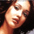 Pixelated close-up of a person's face with light skin tone, dark hair, and a neutral expression against a dark background.