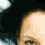 A pixelated image of a person with dark hair, split into two overlapping sections showing different angles of the face against a light background.