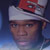 Pixelated close-up of a person wearing a white headband and red cap against a blue gradient background.