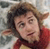 Static pixelated image of a person with brown hair wearing red clothing against a light background.