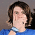 A person with brown hair in a blue shirt appears on the left, while three separate letters O, M, and G are displayed on solid blue backgrounds.