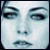 A pixelated face with blue-toned skin and dark eyes, showing a neutral expression in two side-by-side frames.