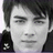 Static pixelated image of a person's face with dark hair, closed eyes, and neutral expression against light background.