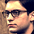 Pixelated image of a person with dark hair and glasses behind vertical bars, with text overlay reading PETER PARKER SONY.COM/ SPIDER-MAN.
