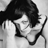 Black-and-white pixelated static image of a person with dark hair and light clothing, cropped to show upper body in profile view against gray background.