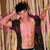 A pixelated static image shows a shirtless figure with dark hair wearing an open black jacket, standing against vertical striped background.