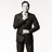Pixelated grayscale image of a person in a dark suit with arms crossed, standing against a plain background.