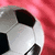 A soccer ball on a red background with text appearing sequentially: 'Invented By Men', then 'Perfected By Women'.