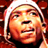 Pixelated static image of a person's face with light-colored hair and warm-toned skin, set against a dark red background.
