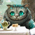 Gray cat with teal eyes sits at a table with a teacup and saucer, holding a small object in its paws.