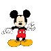 Mickey Mouse in red shorts, black shoes, white gloves, and yellow feet performs a sequence of hand gestures with blue spherical objects against gray background.