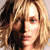 Pixelated close-up of a person with light brown hair and closed eyes, showing partial facial features against a neutral background.