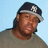 Pixelated image of a person with long brown hair wearing a dark cap and gray shirt against light blue background.