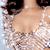 A 2x2 contact sheet of four animated frames showing a woman in a sparkly silver dress with curly hair and large earrings, displayed on a gray background.
