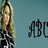 Pixelated image of a person with long light brown hair wearing dark clothing against a gradient background, with partial text 'ABC' visible on the right.