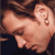 Pixelated close-up of a light-skinned figure's upper body and head, showing a bare shoulder and ear with visible earlobe and earlobe piercing.