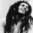 Black-and-white pixelated icon of a figure with long hair and a circular face, rendered in low resolution on a gray background.