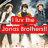 Three figures stand in a row against a blurred background with red text overlay reading "I'm So Jenai Brehall".