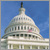 Pixelated image of a large white domed building with columns under a clear blue sky, featuring a small red element on the dome.