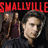 Red pixelated text "SMALLVILLE" spans the top of a dark background with two figures below, one in purple and brown clothing holding an object.