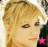 A pixelated close-up of a person with blonde hair and dark eyes, featuring a small pink star on the lower left side.