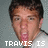A pixelated image of a person with short dark hair wearing a white shirt, with text overlays reading "TRAVIS IS DA BOMB!" and "by: jackie".
