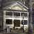 Pixelated static image of a two-story house with a triangular roof, dark windows, and light-colored walls against a dark background.