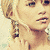Pixelated close-up of a person with short blonde hair and large earrings, showing two distinct facial expressions