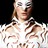 Pixelated static image of a person with light skin tone wearing a white top with brown patterns against a dark background.