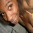 A pixelated close-up of a person's face with light skin tone, brown hair, and visible eye details against a blurred background.