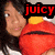 A pixelated image shows a person holding a red plush toy with yellow accents, featuring text overlays that change between frames.
