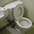 Static 50x50 pixel icon depicting a toilet with visible seat and tank, rendered in low-resolution grayscale tones on a neutral background.